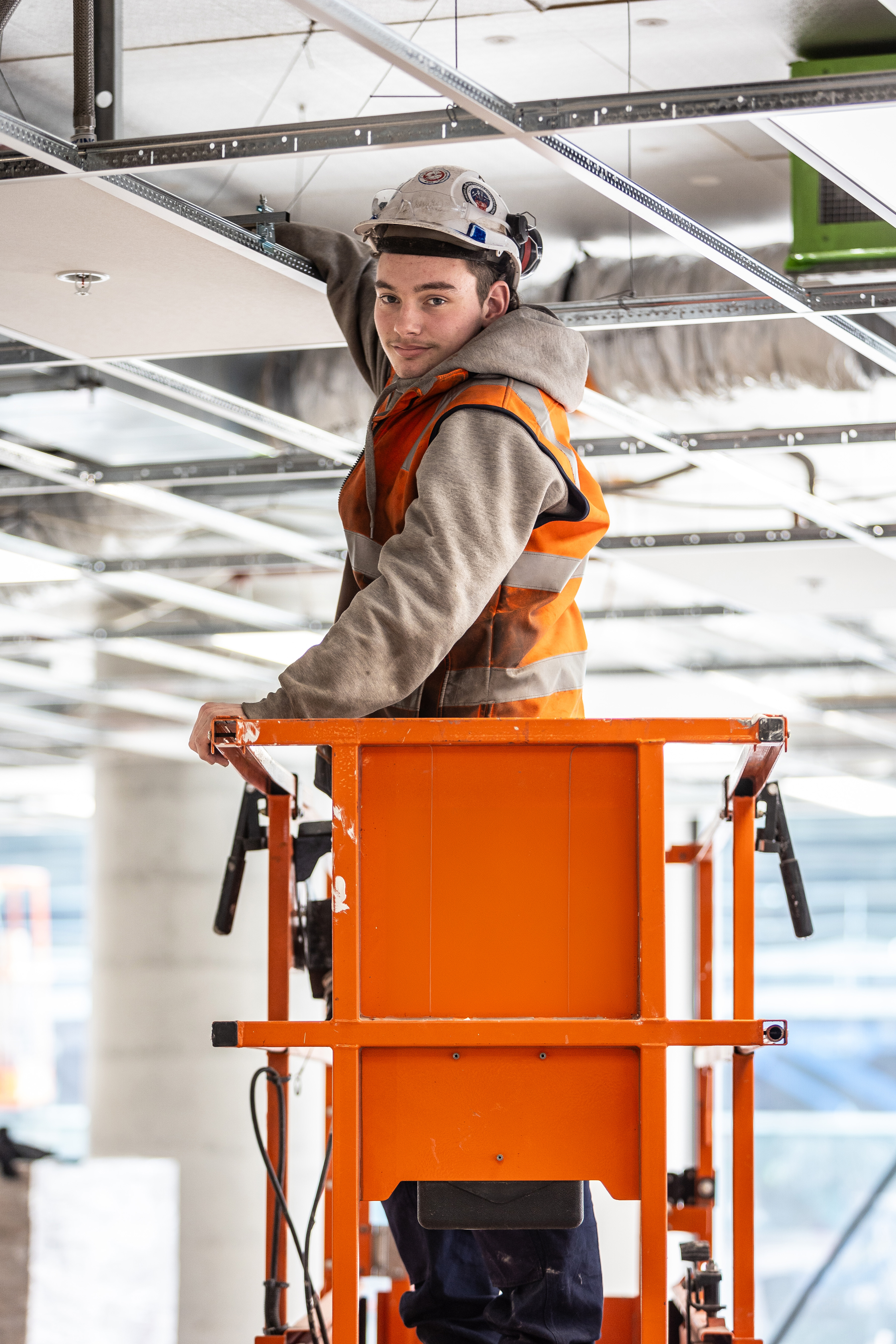 young man commercial building fit out electrician electrical work lighting fit out building clothing human face man outdoor person labour hire high vi vest hard hat