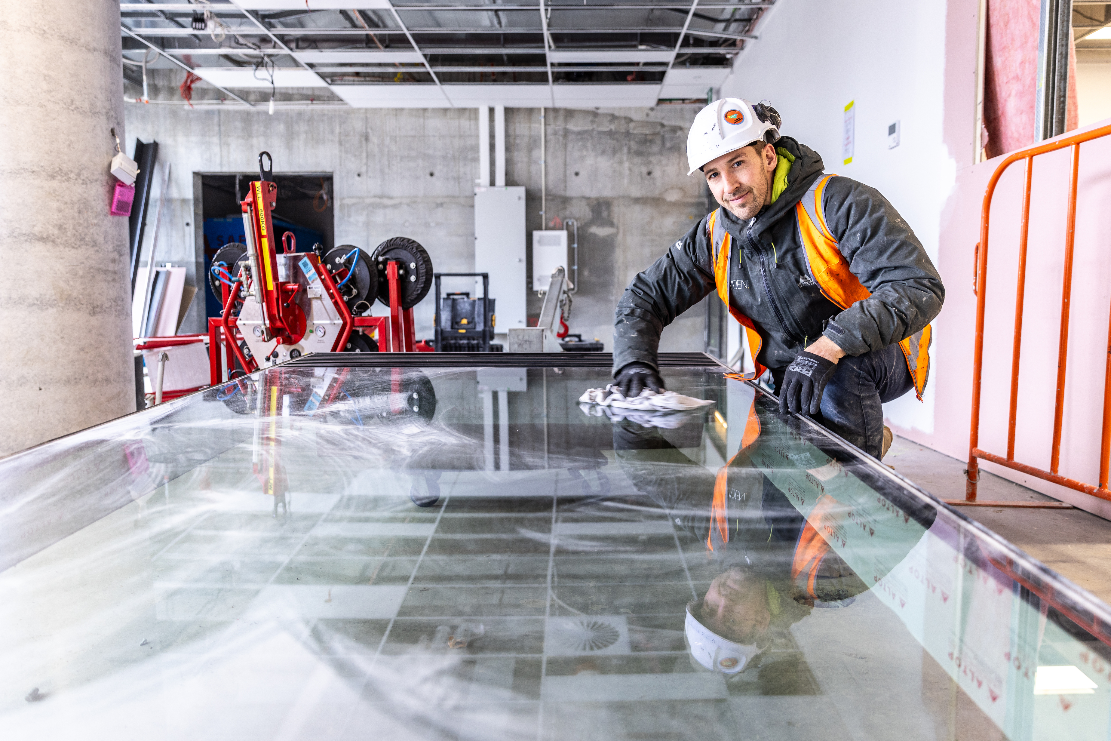 Employers sign-up your apprentice window glazier young man preparing a window for installation hard hat cleaning window blue-collar worker building clothing composite material footwear indoor person workwear