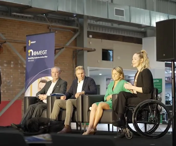 Disability DIAP MEGT panel discussion Disability Inclusion Action Plan woman with disability talking presenting to audience indoors building chair clothing footwear furniture indoor man people person suit wall wheelchair